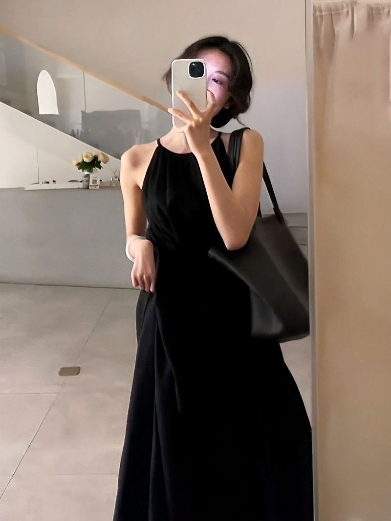 黑色露腰度假风连衣裙2025新款设计感收腰显瘦无袖挂脖长裙女